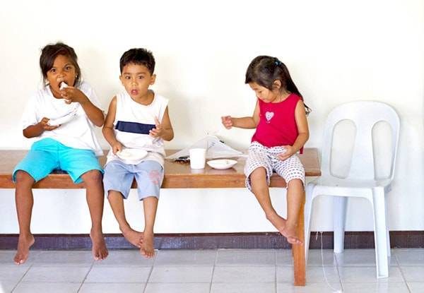 Children sitting on a bench.