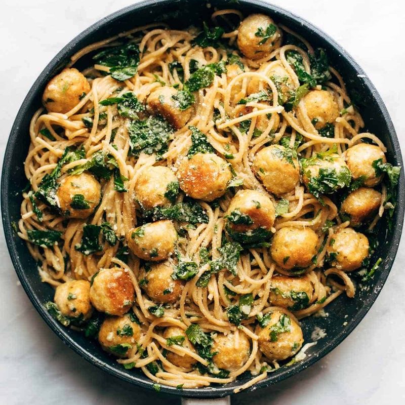Garlic herb spaghetti and meatballs in a pan.