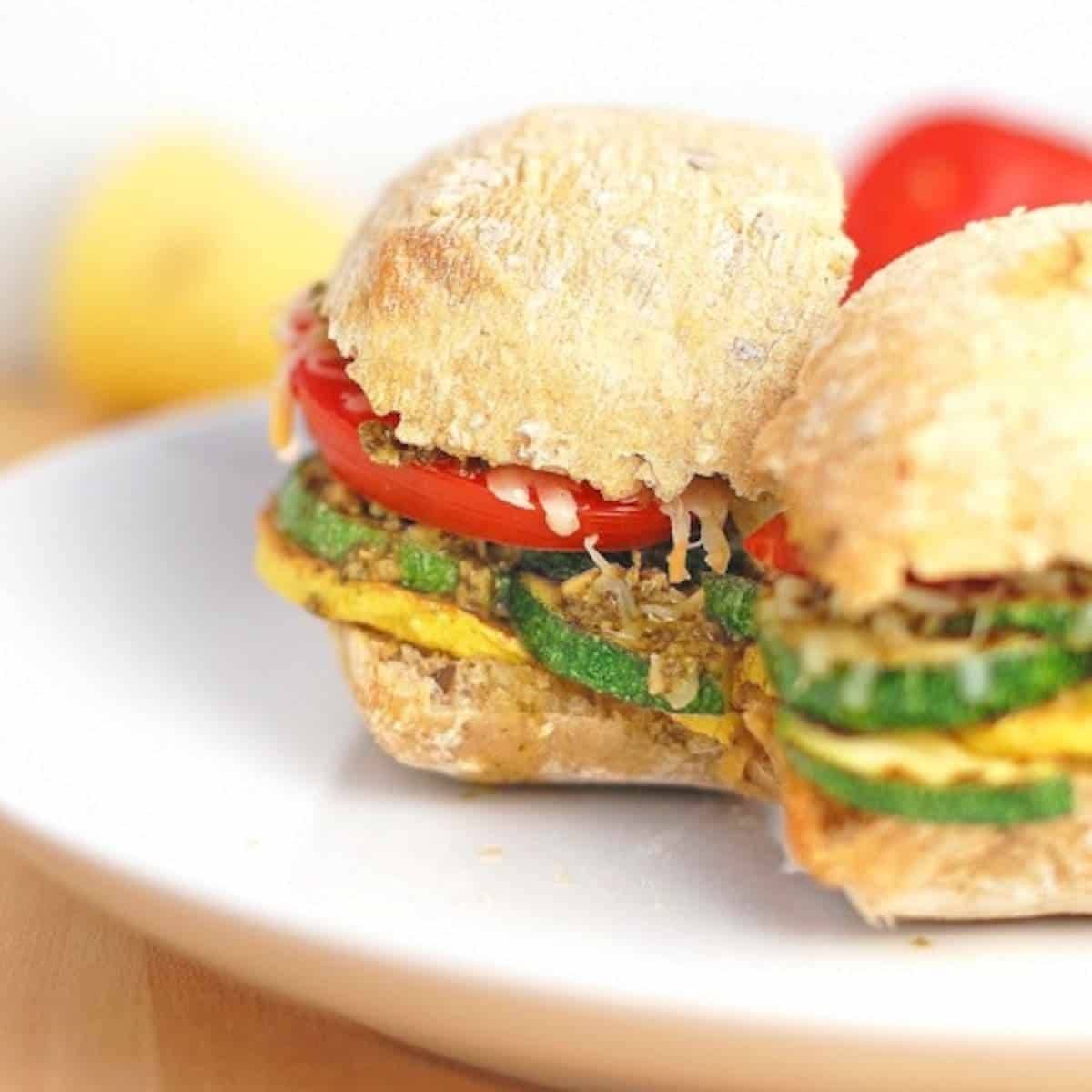 Parmesan and pesto grilled veggie sandwich on a plate.