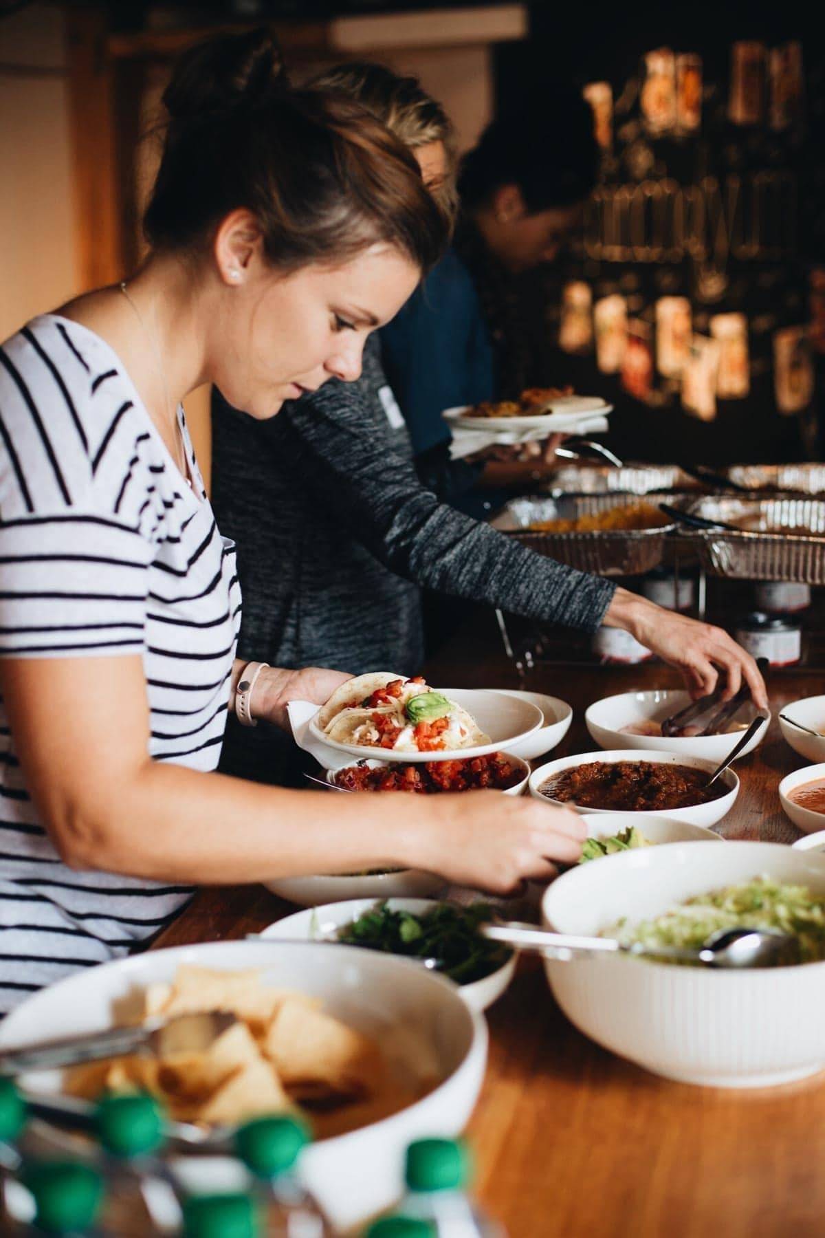 Women putting food on plates.