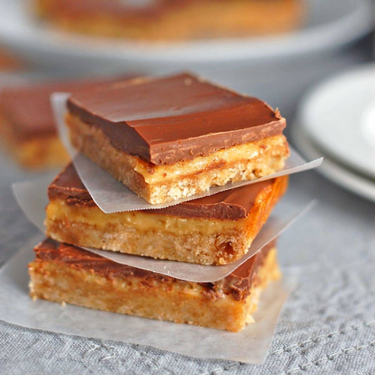 Milk chocolate dulce de leche bars on pieces of parchment paper.